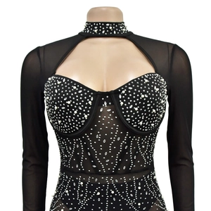 Détail de la combinaison en résille noire avec col ajouré, perles et strass brillants