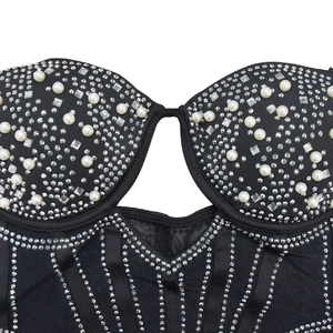 Gros plan détaillé de la robe courte en tulle avec strass brillants et perles blanches