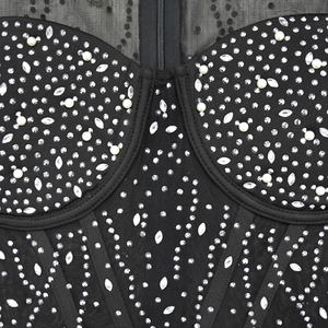 Détail macro d'un body en maille noire avec perles, strass et fermeture éclair avant