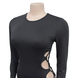 Detail view of black long sleeve top featuring sexy side waist cutout with cross tie design