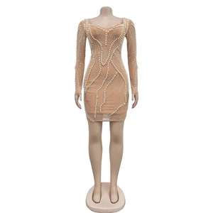 Detail of nude mesh dress featuring white faux pearls and sparkling rhinestones