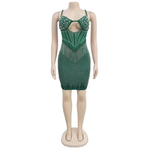 Détail de robe moulante vert foncé avec franges en strass et décolleté en maille perlée