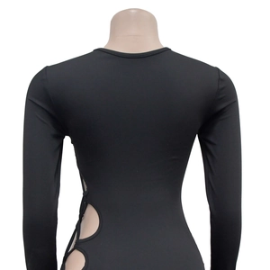 Detail of the side cut-out circular design on a tight black long-sleeve dress