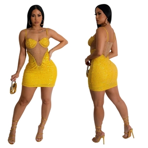 Vue détaillée de la mini-robe jaune à paillettes avec mesh transparent et strass brillants