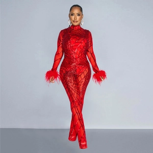 Detail of red mesh jumpsuit with shimmering sequins and elegant feather cuffs for party