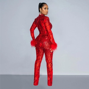 Detail view of red sequin jumpsuit with mesh fabric and elegant feather cuffs