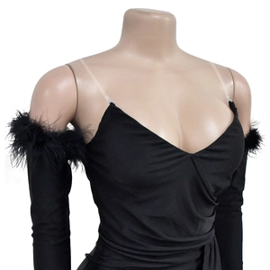 Dettaglio di elegante abito nero con polsini in piume e scollo a V con pieghe