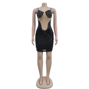 Détail d'une robe moulante noire avec strass argentés et empiècement en maille résille