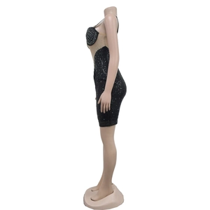 Détails d'une mini robe corset noire avec strass et empiècements latéraux en résille