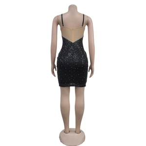 Détail du dos en tulle et des paillettes argentées sur la mini robe moulante