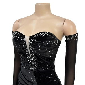 Dettaglio del vestito in velluto nero con strass d'argento e scollatura a V velata