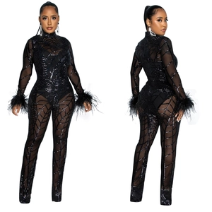 Front and back view of black sheer mesh jumpsuit with sequins and feather cuffs