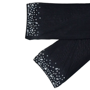 Détail du tissu en maille noire élastique orné de strass brillants en dégradé chic