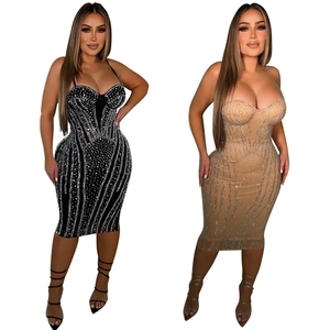 Close-up of sparkling rhinestones on sleek bodycon midi dress in black and apricot