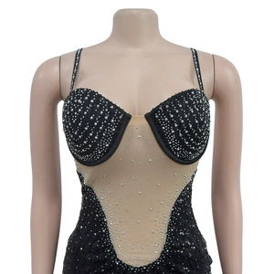 Détail d'une robe en résille noire à strass avec paillettes et empiècement transparent en V