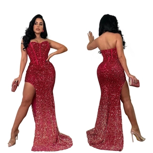 Dettaglio delle paillettes rosse sfumate e dello spacco alto sull'abito da sera elegante