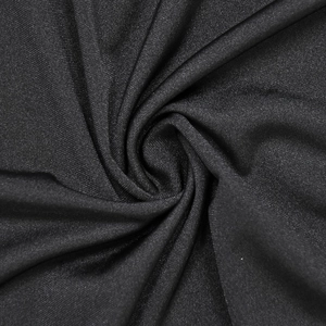 Dettaglio del tessuto a maglia nera arricciata con sottile luccichio e pieghe a spirale