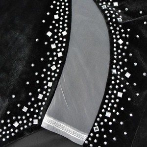 Dettaglio dell'abito in velluto nero con strass argentati e inserto in mesh