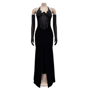 Détail de robe noire en velours fendue avec bustier en strass et gants transparents