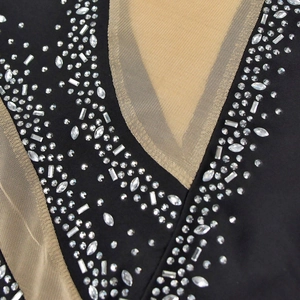 Detail shot of V-neck mesh dress with sparkling rhinestones and transparent sequins