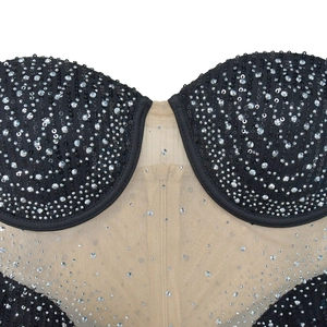Gros plan détaillé de strass argentés et paillettes sur une robe de soirée en résille