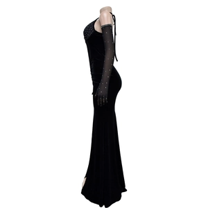 Détail d'une robe de soirée en velours noir à fente avec gants ornés de strass brillants