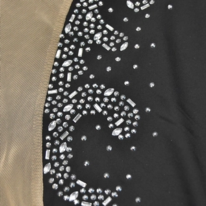 Detail of mesh stitching and sparkling rhinestones on an elegant sleeveless party dress