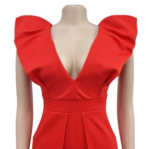 Détail de la combinaison rouge avec col en V profond, manches bouffantes et taille plissée