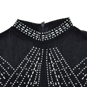 Detail of mock neck black mesh jumpsuit with silver rhinestone patterns and hidden zipper