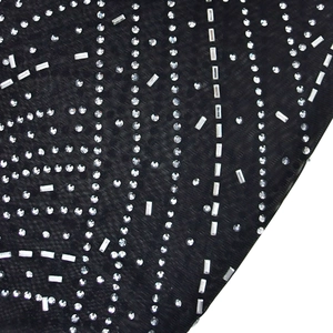 Detail of silver rhinestones in curved stripes on black mesh fabric for jumpsuit