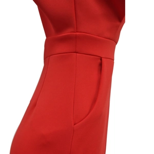 Détail de la combinaison rouge montrant la taille haute et la poche latérale discrète