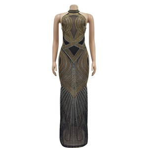 Détail d'une robe longue en maille avec des strass et des perles complexes sur tissu transparent