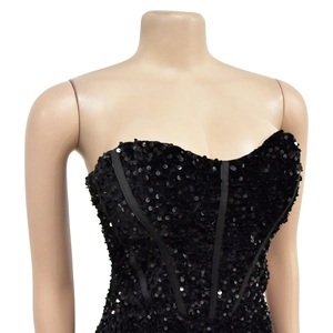 Dettaglio del corsetto di paillettes nere con scollo a cuore e stecche di supporto