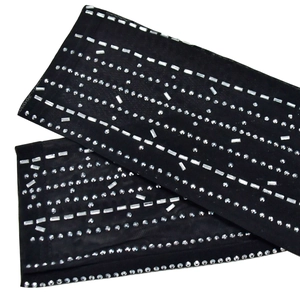 Detail of black mesh sleeves with sparkling rhinestone stripes and crystal embellishments