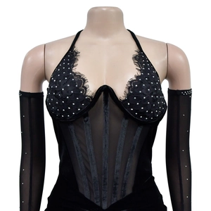 Détail d'un body en velours noir avec strass, dentelle et manches en résille
