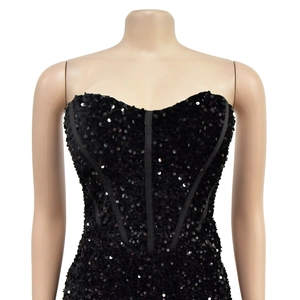 Dettaglio del corsetto nero con paillettes e struttura a stecche su manichino sartoriale