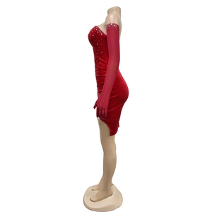 Dettaglio dell'abito corto in velluto rosso con strass e guanti lunghi coordinati