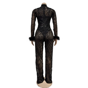Detail of back view mesh jumpsuit with sequins, high neck, and faux fur cuffs