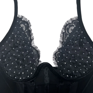 Vue détaillée de la lingerie en velours noir et dentelle avec strass argentés et armatures