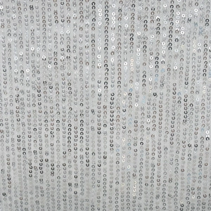 Detailed close-up of vertical silver sequins on white mesh fabric for long dresses