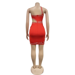 Macro detail of red one-shoulder mini dress featuring rhinestone patterns and side cutout