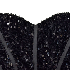 Dettaglio del corsetto nero con paillettes e stecche strutturali verticali interne