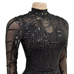 Detail of sheer black mesh top featuring intricate sequin spider web patterns