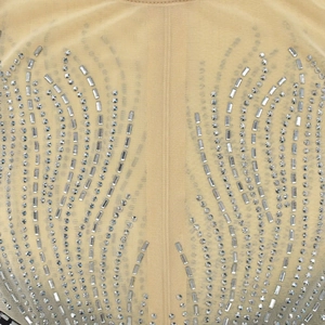 Détail du tissu en maille beige avec motif plume en strass argentés et design d'ailes