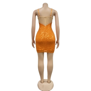Détail de la robe moulante orange à paillettes avec dos en résille strass et zip discret