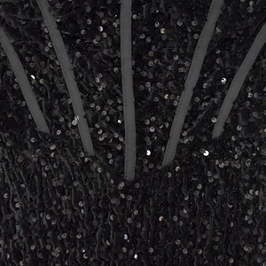 Dettaglio dell'abito con paillettes nere con stecche verticali e texture luccicante