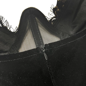 Détail macro de la fermeture éclair invisible et de la dentelle noire sur robe en velours