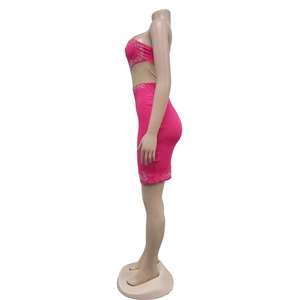 Detail of hot pink bodycon dress featuring silver rhinestones and side mesh cut-outs
