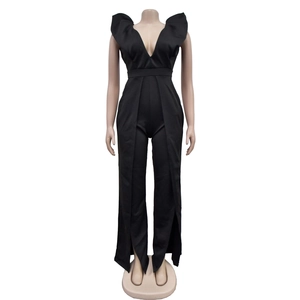 Détail d'une combinaison noire à col en V profond, volants et jambes larges fendues