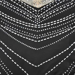 Détail des strass en forme de V sur le col de la robe noire sans manches à paillettes